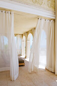 Veranda einer herrschaftlichen Villa mit luftigem Vorhang vor Arkaden