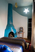 Moroccan bedroom with blue-painted corner fireplace and star-shaped wall lamp