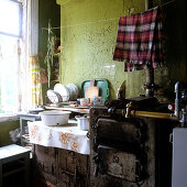 Tea towel hung above rustic, grimy stove to dry