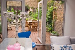 Planted courtyard terrace of town house seen from eclectic kitchen-dining room