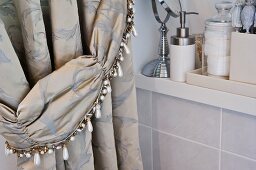 Elegant brocade curtain in bathroom with beaded tie-back