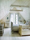 Wood-panelled attic bedroom with cot and double bed