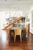 Modern dining table and wooden shell chairs in open-plan interior