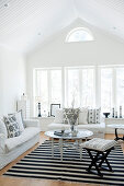 Pale attic interior with white sofa set and Oriental side table on black and white rug