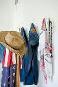 Straw hat, Stars-and-Stripes scarf and clothing hung from rack made from white-painted antlers