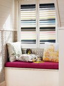 Window seat at window with striped louver blinds