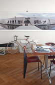 Tisch und Stuhl im Bauhausstil vor Wand mit grossformatigem Foto und Fahrrad