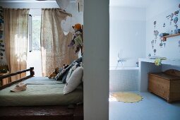 Blick ins Schlafzimmer und ins Bad, getrennt durch Raumteiler