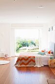 Bedroom with wooden floor and double bed in front of wide open patio doors