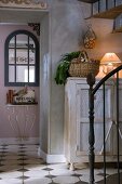 Foyer of old country house in shabby chic style with artistic metal staircase and original antique console table in background