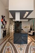 Hypermodern kitchen island with extractor hood in open-plan interior with ornamental terrazzo floor