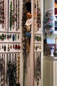 Necklaces and earrings hanging on wall hooks
