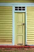 Front door of yellow-painted wooden house