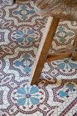 Rustikaler Holzschemel auf Vintage Fussboden mit gemusterten Fliesen
