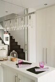 Pendant lamp with glass bead ornaments above angled base unit in designer kitchen