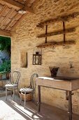 Waschtrog neben grau lackierten Thonetstühle vor Natursteinwand eines mediterranen Hauses