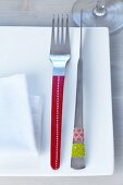 Designer cutlery decorated with patterned tape on square plate