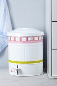 Vintage-style metal pedal bin decorated with patterned tape