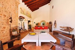 Offener Wohnraum mit modernem Couchtisch und antiken Stühlen in mediterranem Landhaus