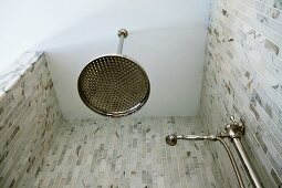 Kopf- und Handbrause im Retrostil in gemauerter Dusche mit grau geflammten Marmorfliesen