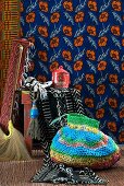 Brightly striped crocheted bag in front of stool and African-style floral wall hanging