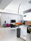 Designer Wohnraum mit farbigen halbhohen Schränken und klassischer Bogenlampe