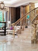 Marble staircase and decorated brass railing in the foyer of an elegant villa