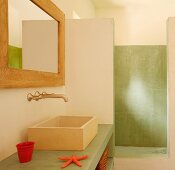 Waschbereich mit trogartigem Becken auf grüner Betonplatte und Vintage Wandarmatur neben abgetrennter Dusche mit grüner Wand