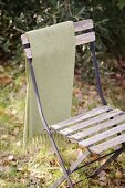 Vintage garden chair with blanket hanging on back