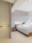Schlichtes Doppelbett mit Holzgestell in minimalistischem Schlafraum