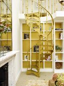 Vintage spiral staircase in front of modern fitted shelving against yellow wall in traditional setting