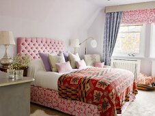 Double bed with upholstered headboard and ethnic bedspread in simple bedroom