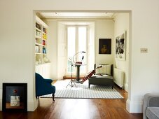 View through wide doorway into music room with music stand and instrument leaning against chaise longue next to balcony door