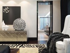 Sideboard mit metallisch glänzender Front in schwarz weißem Designer Wohnraum