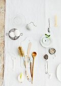 Various kitchen utensils spread out on white tablecloth