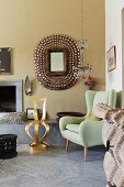 Lime green, retro wingback armchair and gilt chair in front of hand-crafted mirror on wall next to open fireplace