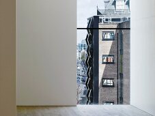 View through a floor to ceiling window of a contemporary apartment building (Photographers' Gallery, London)