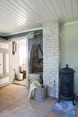 Scandinavian room with antique log burner, brick chimney, baskets and cloakroom area