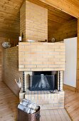 Brick open fireplace with birch logs stacked in copper bucket
