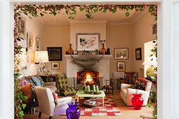 Various armchairs and roaring open fire in living room decorated for Advent