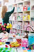 Woman in front of shelves of colourful boxes in a shop