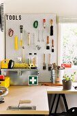 Kleine Werkstatt mit Werktisch und Werkzeugwand in Gartenhäuschen