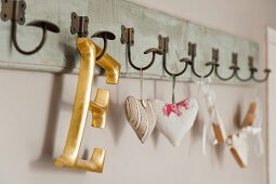 Gold, wooden letter ornament and scented sachets hanging on peg rack