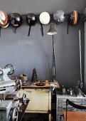 Collection of motorbike helmets hanging on grey wall and vintage machines in cellar room