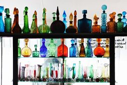 Reizvolle, farbige Flaschen und Vasen in Raumteilerregal