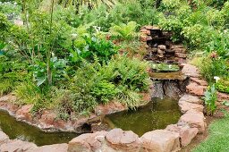 Waterfall and stream formed from boulders in tropical garden