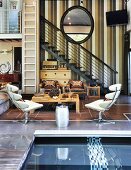 Wohnzimmer mit Galerietreppe und Wasserbecken im Retro Stil mit amerikanischem Flair