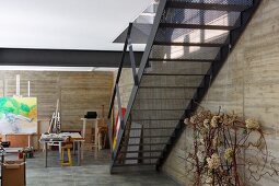 Metalltreppe in hellem Atelier mit Betonwänden
