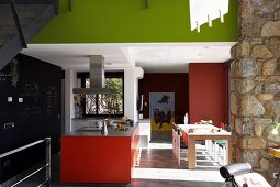 Moderne Küche mit farbigen Flächen in Rot und Frühlingsgrün im offenen Wohnraum
