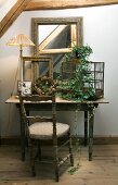 Rustikaler Holztisch mit Antiquitäten; davor ein Vintage-Stuhl
